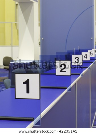 Numbered stations along blue registration counter in convention hall