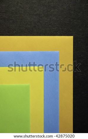 Four colored envelopes on black cardboard