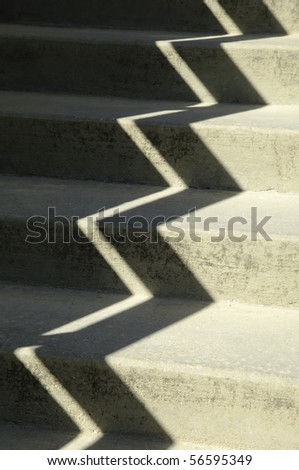 Zigzag shadow on sunlit concrete stairway