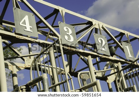 Numbers one through four atop old schooling gate on equestrian training track