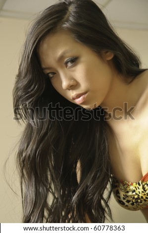 Office fantasy: sideways look from beautiful young Asian-American woman in bikini top