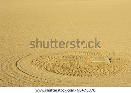 Pattern of rake marks in dirt around pitcher\'s mound on baseball diamond