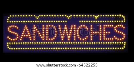 Neon sign on black background: SANDWICHES