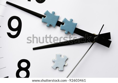 Delivery time: Minute hand of analog electric clock carries two pieces of jigsaw puzzle, with a third on the white face