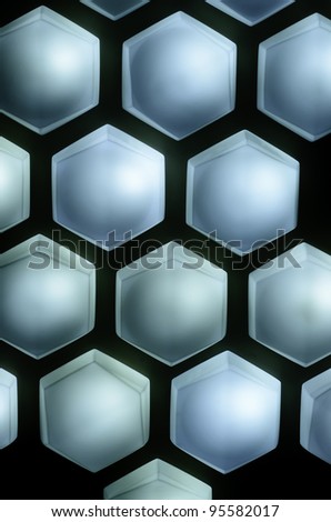 Hexagonal light fixtures in a pattern on dark wall