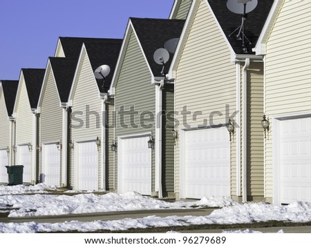 Building conformity: Row of nearly identical one-car garages in winter