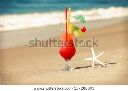 cold fresh bright cocktail on sand near sea