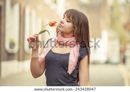beautiful woman smelling tulip on the street of London