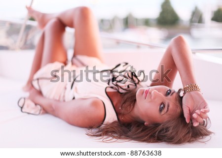 portrait of young beautiful woman lying on yacht