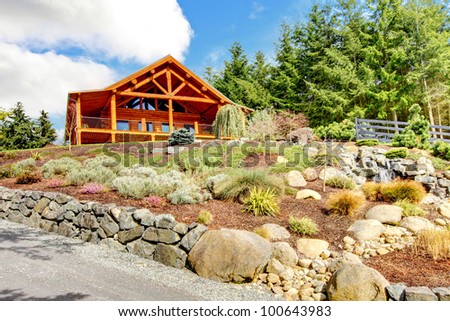 Beautiful Log cabin on the hill with waterfall and flowers.
