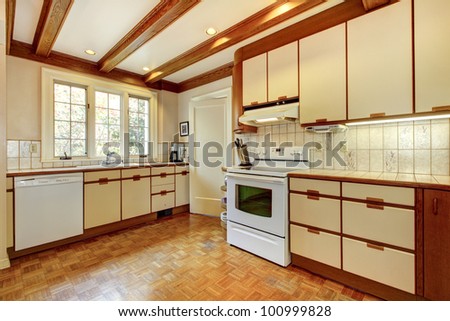 Old simple white and wood kitchen with hardwood floor and white appliances.
