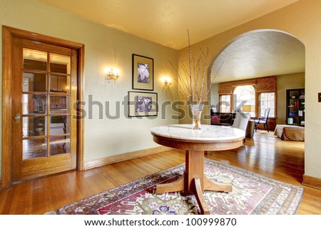 Luxury entrance home interior with round table and hardwood floor.