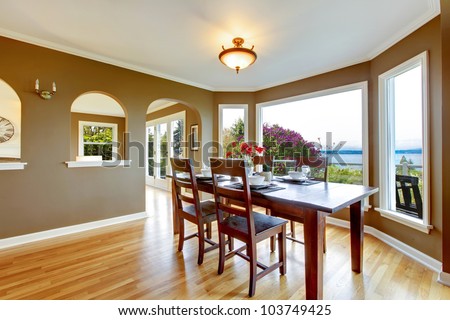 Dining Room With Brown Walls And Wood Table With Water View. Stock ...