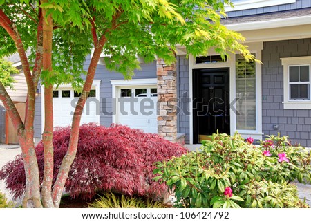 Beautiful new great house with two garage doors and front black door.