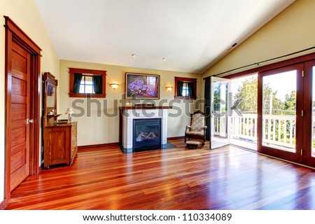 Room with beautiful chery hardwood floor and fireplace with open doors to the balcony.