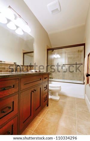 Nice bathroom with wood luxury cabinet and ceramic tile.