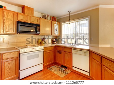 Wood and beige wall American standard kitchen with white appliances.