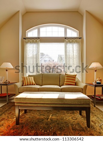 Living room with large window and classic sofa with table.