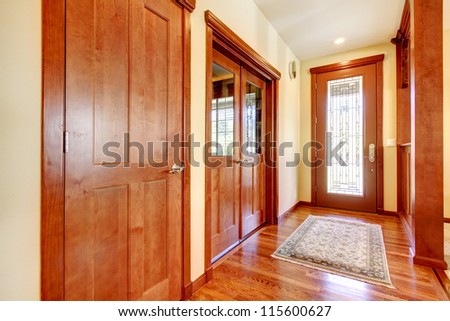 Luxury hallway and house entrance with cherry wood ad yellow walls.