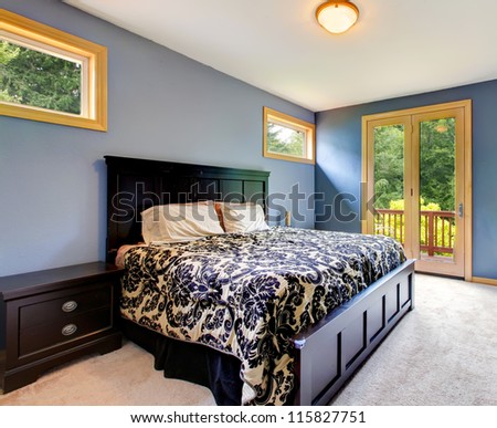 Blue modern bedroom with balcony door and beige carpet.
