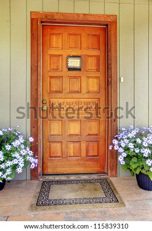 House wood carved old front door with blue flowers.