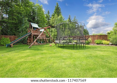Play Kinds Ground Area With Trampling In Fenced Backyard During Summer.