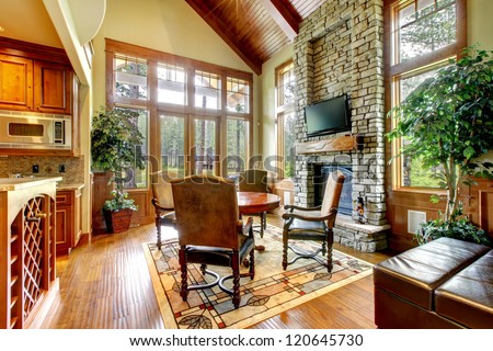 Luxury mountain home dining and living room with stone fireplace.