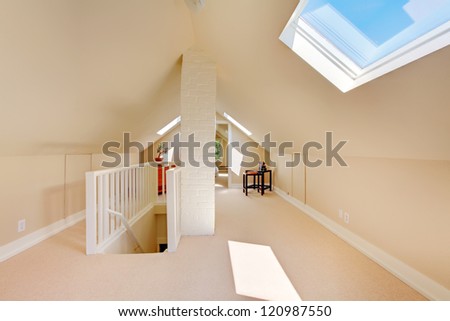 Bright clean attic in the small home with beige carpet.