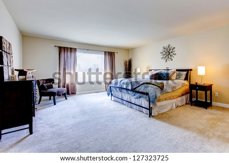 Large Bedroom Interior With Beige Carpet And Black Bed.