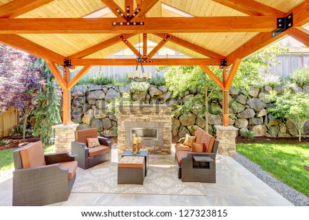 Exterior Covered Patio With Fireplace And Furniture. Wood Ceiling With Skylights.