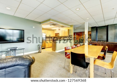 Apartment building modern living room with kitchen general area with TV.