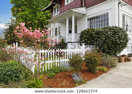 Classic large craftsman old American house exterior in red and white during spring.