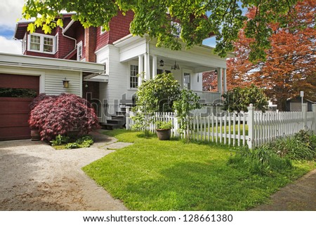 Classic large craftsman old American house exterior in red and white during spring.