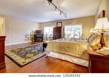 Large bedroom with hardwood floor and two dressers.