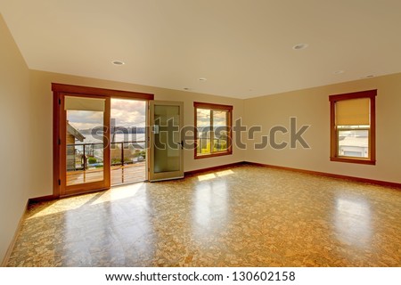 Large bright empty room with cork floor and balcony.New luxury home interior.