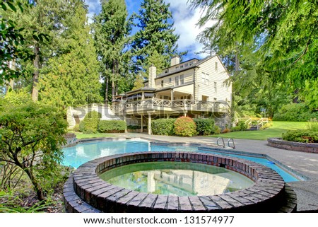Large brown house exterior with summer garden with swimming pool. Northwest.