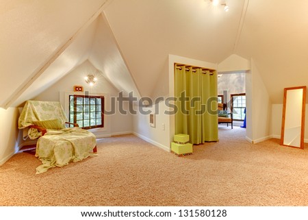 Attic room with chair, mirror and play room with clothes.