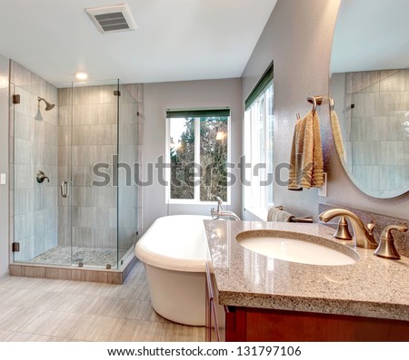 Beautiful Grey New Modern Bathroom Interior With Glass Shower And Tub.