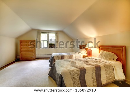 Attic bedroom with simple furniture and vaulted ceiling.