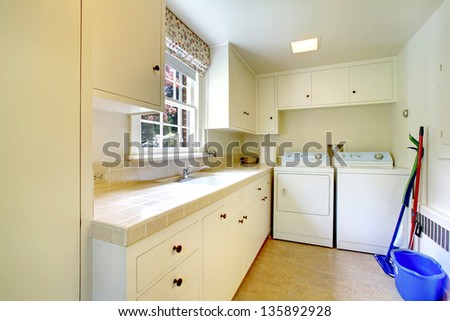 Laundry room with white old cabinets in large historical home.