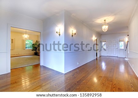 Large bright hallway with hardwood floor and dining room.