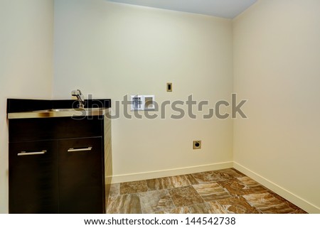 Empty new laundry room with sink and cabinet.