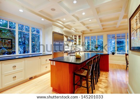 White large luxury kitchen with huge wood island and refrigerator.