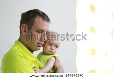 Daddy\'s girl. Young father is holding baby girl. Both wearing neon green.