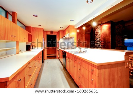 Wood orange long retro kitchen in luxury Seattle home with copper fireplace.