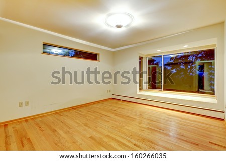 Empty modern room with new hardwood, window seat and beige white walls. Luxury American home. Evening.