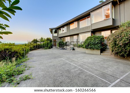 Large brown home with huge back yard. Luxury real estate exterior. Typical NorthWest home in US. Private tennis court.