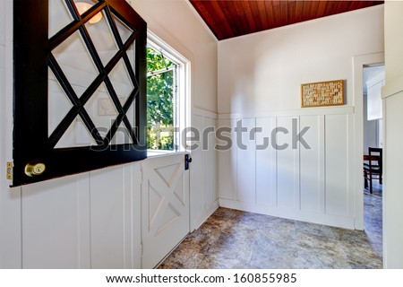 Old half cut door with mud room and white wall molding. American traditional home interior.
