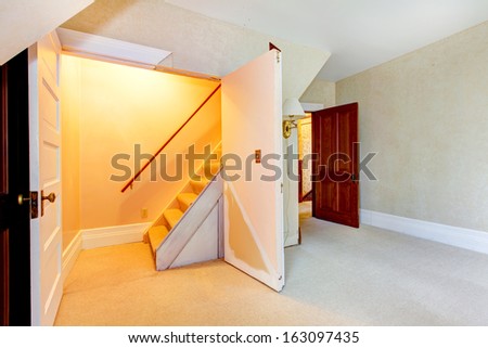 Old house empty interior with closet doors open do the attic staircase.