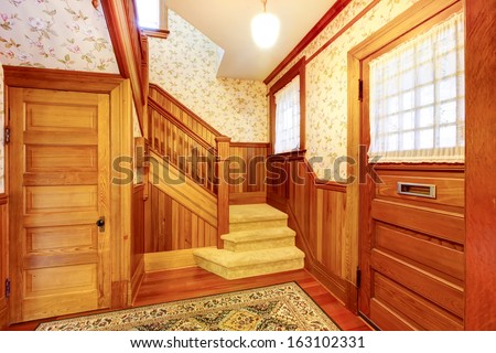 Hallway with staircase and two doors. Old American craftsman style home with lots of wood details.